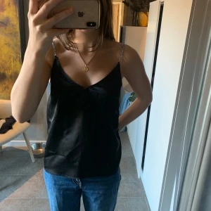 Svart satinlinne med glittriga axelband - Snyggt svart satin linne från H&M i storlek XS. Endast använd fåtal gånger.