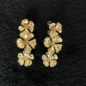 Guldörhängen med blommor - Snygga guldörhängen med flera blommor i rad. Perfekta för att ge en elegant touch till din outfit. Köpta för 220kr (lånade bilder) skriv innan köp🔥 pris kan diskuteras💕