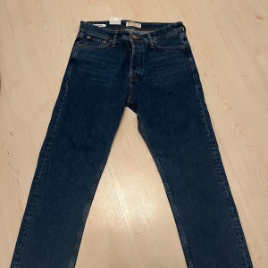 Blåa jeans från Jack & Jones - Säljer ett par snygga blå jeans från Jack & Jones i loose fit. De är i bra skick och perfekta för en avslappnad stil. Fick i julklapp förra året men har aldrig använts. Hör av er vid ytterligare frågor