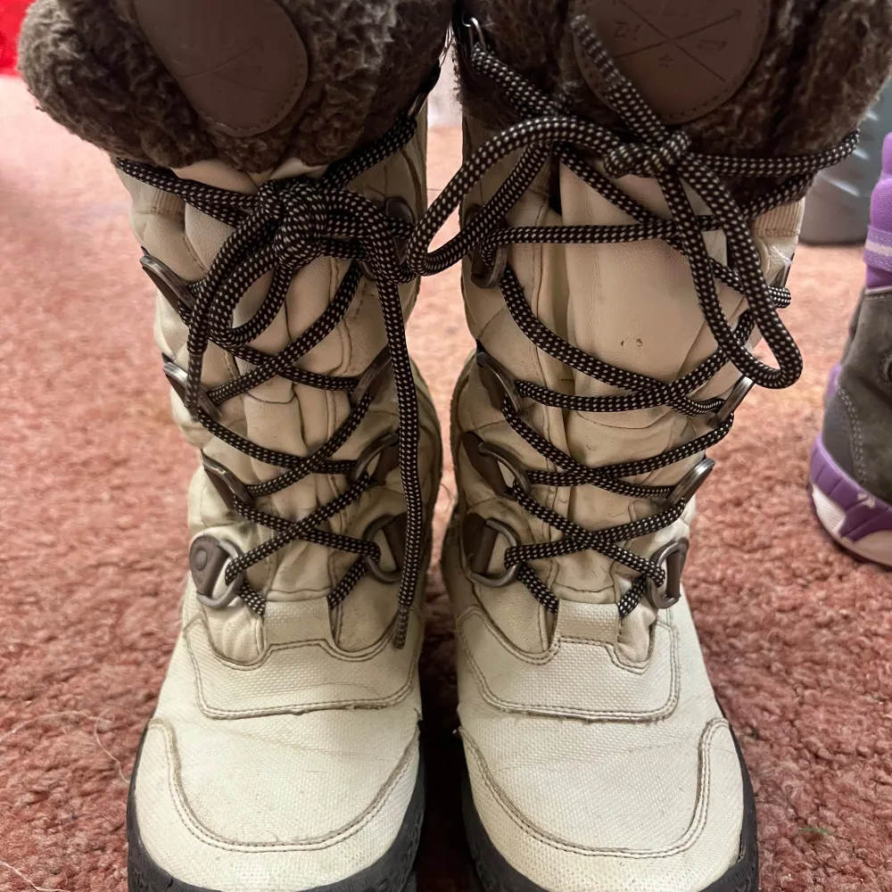 Säljer ett par varma vinterstövlar i beige med snörning och mysigt foder. Perfekta för kalla vinterdagar. De har en robust sula och är i bra skick. Passar både för promenader i snön och vardagsbruk.. Kengät.