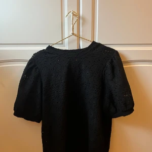Svart blus  - Svart T-shirt med puffärmar som har håll i sig