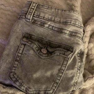 Grå jeansshorts från Gina Tricot - Säljer ett par snygga grå jeansshorts från Gina Tricot i storlek 170. De har en cool tvättad look och är utrustade med knappar och fickor både fram och bak. 