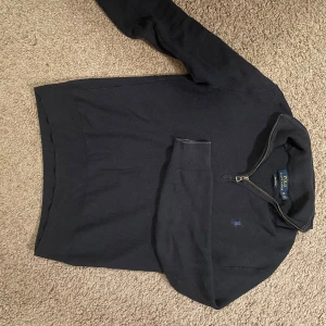 Marinblå halv-zip från Polo Ralph Lauren - Säljer en stilren halv-zip tröja från Polo Ralph Lauren i pima bomull. Tröjan har en dragkedja vid halsen och långa ärmar. Perfekt för både vardag och lite finare tillfällen. Storleken är XS och priset kan diskuteras.