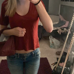 Röd kortärmad topp - Säljer en vin röd kortärmad topp i ett mjukt och bekvämt material. Toppen har en enkel design med rund hals och är perfekt för vardagsbruk. Den är lätt att matcha med jeans eller kjol för en avslappnad look. Liten i storlek.