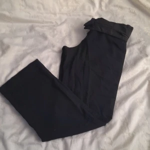 Marinblåa kostymbyxor från KappAhl - Säljer ett par stilrena marinblåa kostymbyxor från KappAhl i storlek 38. De har en klassisk design med normal passform och är perfekta för både vardag och ute. Byxorna är i bra skick och har en enkel dragkedja framtill.