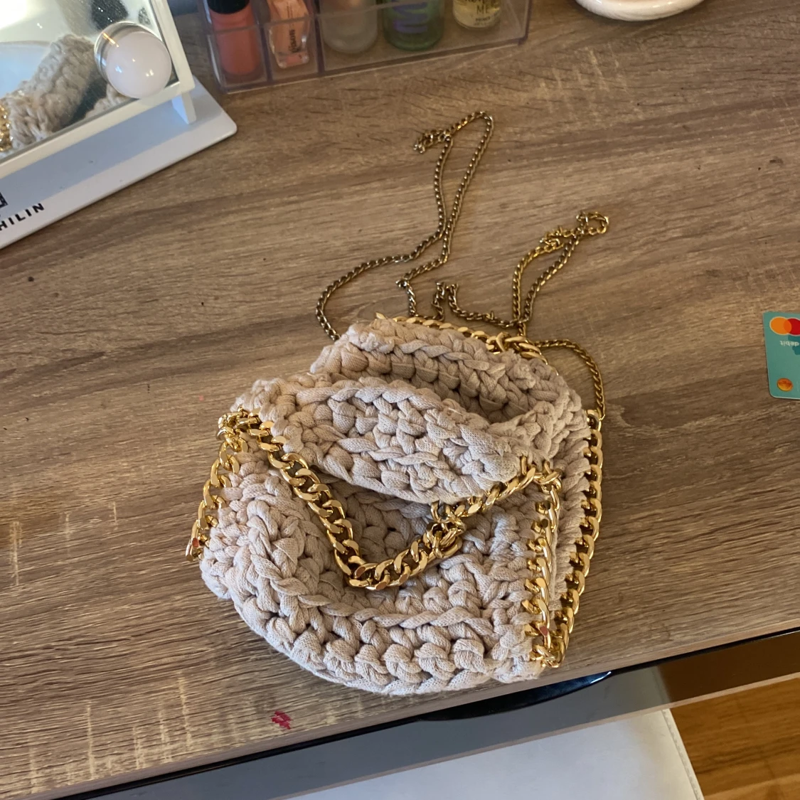 Beige stickad axelväska med guldkedja