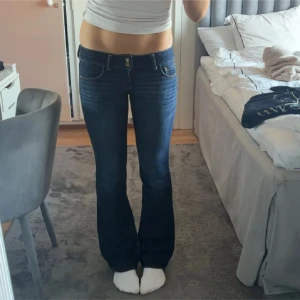 Mörkblå bootcut jeans från American Eagle - Säljer ett par skitsnygga mörkblå bootcut jeans från American Eagle som tyvärr är för stora på mig. De är lågmidjade och har en klassisk femficksdesign. Perfekta till både vardag och fest. Innerben: 80-81, midjemått: 39-40