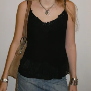 Svart zara topp med spets - Snygg svart ärmlös topp med spetsdetaljer vid halsringningen. Genomskinlig med svart tyg under. Storlek S/M. Kolla profilen för fler plagg! 