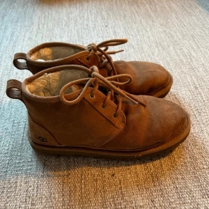 UGG Skor - Säljer ett par bruna UGG boots i mocka med mjukt foder inuti. Perfekta för höst och vinter när du vill hålla fötterna varma och bekväma. Är i bra skick 8,5/10. Hör av er vi eventuella frågor😁👌