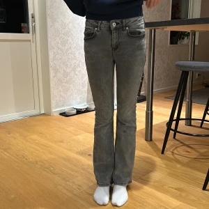 Grå bootcut jeans - Säljer ett par snygga grå bootcut jeans i bra skick. De är medelmidjade och har en klassisk femficksdesign. Grunt Texas low flare. Perfekta för både vardag och fest! Passar till allt och ger en skön retrovibe. 🕺