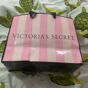 Säljer en snygg shoppingväska från Victoria's Secret i rosa och vit randigt mönster. Perfekt för en shoppingrunda eller som en stilren presentpåse. Väskan har svarta handtag och är i bra skick. Passar perfekt för alla som älskar mode och stil! 💖 50kr och några fläckar finns men inget jätte tydligt 