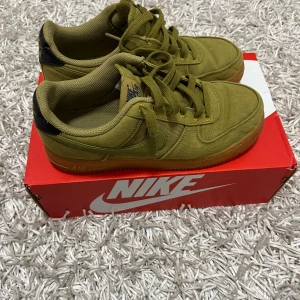 Nike Air Force  - Säljer ett par unika Nike Air Force i olivgrön färg. Skorna är i bra skick och har en snygg design med snörning. Perfekta för både vardag och fest. De har en klassisk Nike Air-sula för extra komfort.