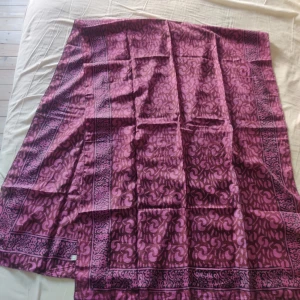 Mönstrad sidensjal  - Säljer en elegant lila sjal i rent silke med ett vackert mönster. Perfekt för att ge en färgklick till din outfit. Tillverkad i Indien och känns superlyxig mot huden. Passar bra till både vardag och fest!