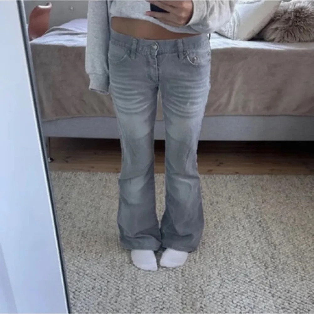 Säljer ett par grå lågmidjde bootcut jeans som jag köpte på vinted men tyvärr så passade det inte. Storlek S. Midjemått: 37 cm tvärs över. Innerbenslängd 79. De har slitningar längst ner men inget som syns när dom är på!!. Farkut & Housut.