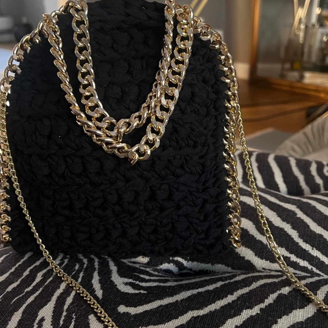 Svart stickad axelväska med guldkedja
