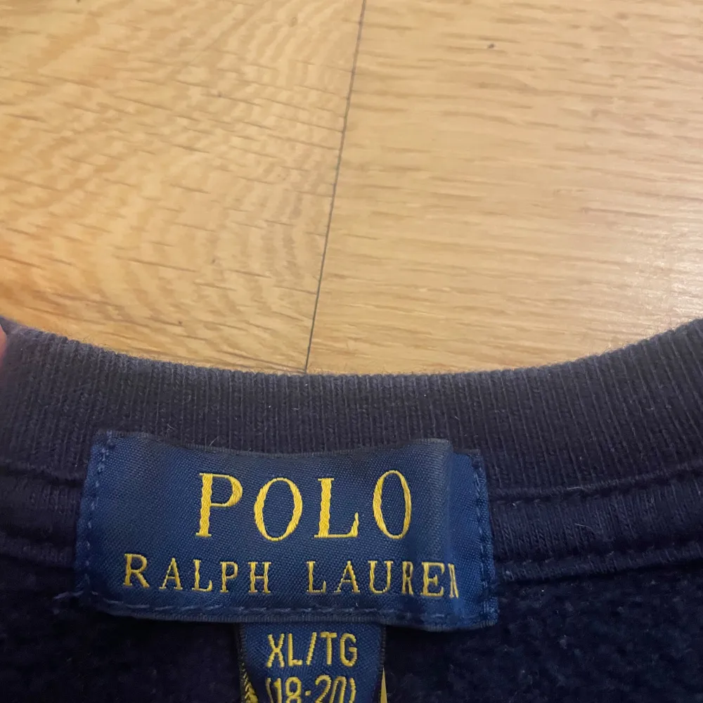 Säljer en klassisk mörkblå sweatshirt från Polo Ralph Lauren i storlek XL. Tröjan har en röd broderad logga på bröstet och är i mycket bra skick. Perfekt för höst och vinter, med långa ärmar och en bekväm passform. Passar både till vardags och lite mer avslappnade tillfällen.. Tröjor & Koftor.