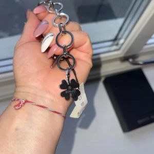 Silverfärgat armband från Edblad - Snyggt armband från Edblad i silverfärg med stora länkar och en fyrklöverberlock. Perfekt för att ge en stilren touch till din outfit. Armbandet är i nytt skick och kommer i originalförpackning. Passar både till vardag och fest!