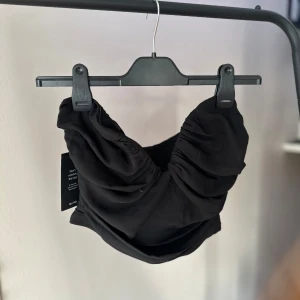 Svart topp från NAKD - Svart korsett topp i nyskick, lappar kvar. 