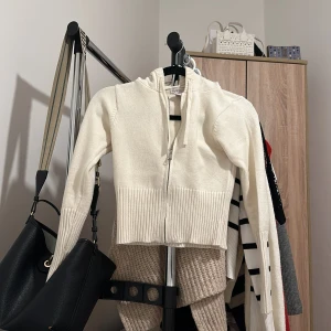 Vit ribbad kofta från Sincerely Jules - Säljer en superfin vit kofta från Sincerely Jules. Den är ribbad och har en dragkedja framtill. Perfekt för både höst och vår, och den är i mycket bra skick. Passar till alla tillfällen när du vill vara både bekväm och stilren.