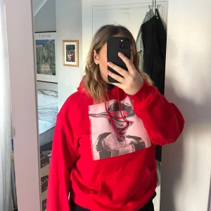 Röd hoodie/bluza z kapturem - Säljer en cool röd hoodie i storlek M. Den har ett unikt tryck på framsidan med en abstrakt design. Perfekt för höst och vinter, och den är superbekväm med en normal passform. Perfekt för att hålla sig varm och stilren!