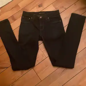 Säljer ett par mörk blå jeans från Nudie Jeans i storlek W27 L34. De är i mycket bra skick och har en slim passform. Perfekta för både vardag och fest! 🖤