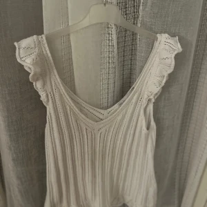 Vit stickad topp från ONLY - Säljer en söt vit stickad topp från Dily Life i storlek XS. Toppen har volangdetaljer vid axlarna och en v-ringad design. Superfin och i bra skick!