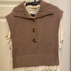 Brun ribbad väst med knappar - Säljer en snygg brun ribbad väst med stora knappar framtill. Säljer den också med en skjorta som jag tyckte passade jättefint till! Använt 2 gånger. 