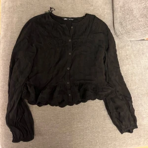 Svart Zara blus  - Superfin svart blus från Zara i storlek M. Blusen har knappar framtill och har små volanger längst ner. Knappt aldrig använd så den är i superbra skick.