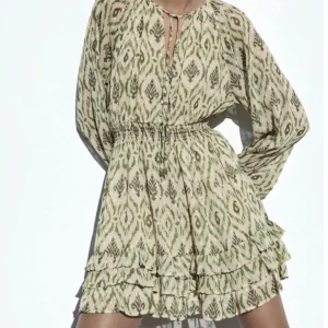 Mönstrad klänning från Zara - !HELT NY! Säljer en superfin mönstrad klänning från Zara. Den har långa lösa ärmar och en smockad midja som ger en snygg passform. Klänningen är kort och har volangdetaljer längst ner. Perfekt för både vår och sommar! Kan användas när som! Lappen är kvar💚