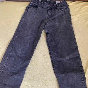 Svarta jeans från Jack & Jones - Säljer ett par gråa Jack&Jones relaxed Chrisbyxor. Eftersom det är inte min stil längre. Det finns ett hål i fickan som man ser på bilden och så är taggen lite söndrig. Lite stora i storleken 