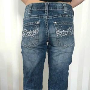Blå jeans med broderade detaljer - Sällsynta low waist bootcut jeans från cowgirl tuff. Vintage. Bra skick förutom slitningar vid hälarna