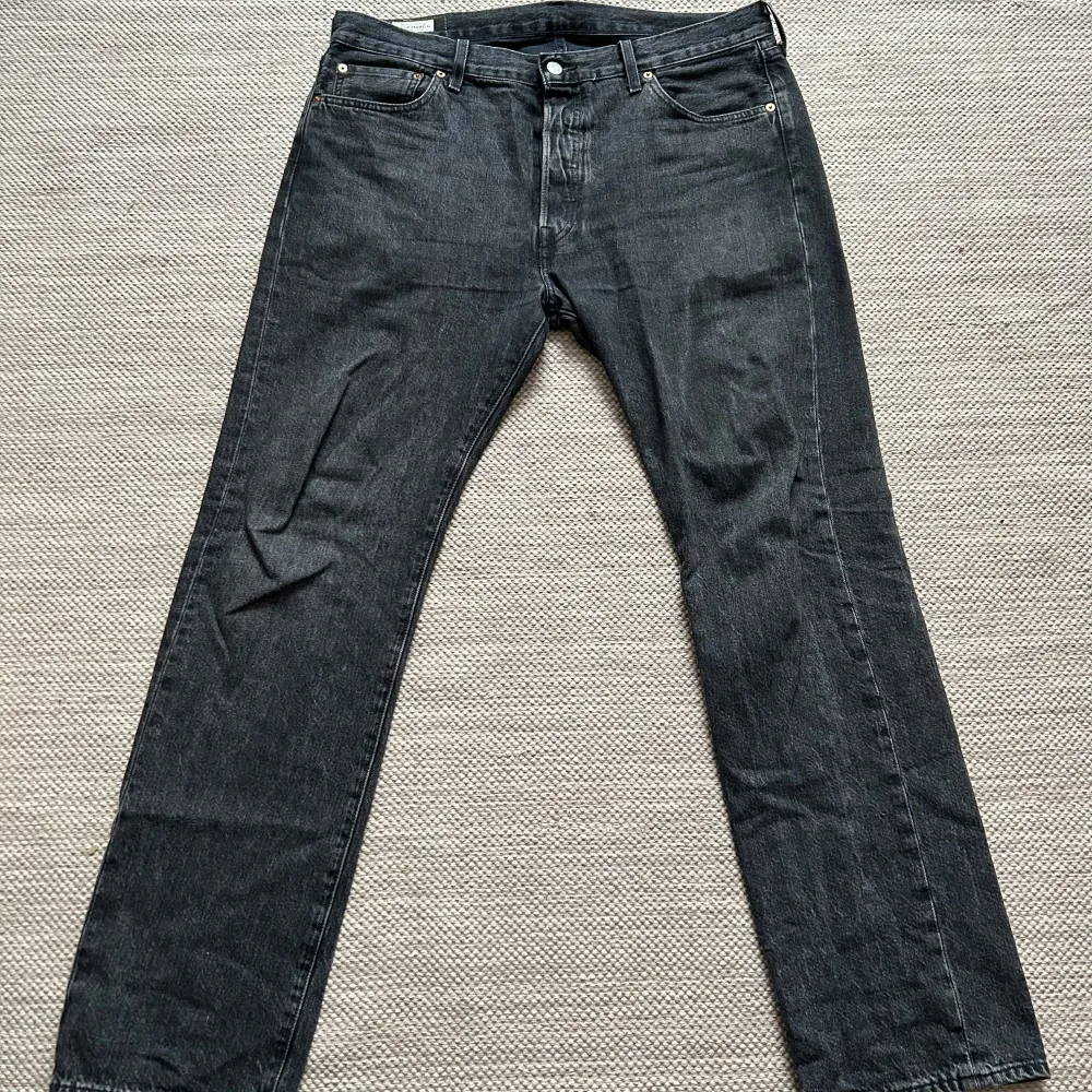 Säljer ett par klassiska svarta Levi's 501 jeans i storlek W36 L32. De är i bra skick och gjorda av 100% bomull. Perfekta för både vardag och fest med sin tidlösa design och raka passform.. Jeans & Byxor.