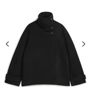 Svart jacka i luddig ullblandning från Arket - Säljer en stilren svart jacka i luddig ullblandning från Arket. Den har en hög krage med knappar och långa ärmar. Använd någon måndag förra vintern/ hösten. Men kommer inte till användning då jag inte gillar hur den sitter på mig. Men i helhet är det sjukt snygg. Storlek 34 och är minsta storleken på hemsidan. Nypris runt 2000kr 