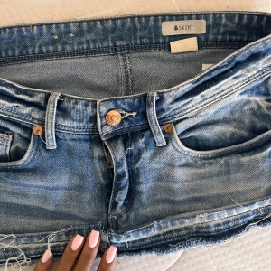 Blå jeanskjol från &Skirt - Säljer en snygg blå jeanskjol från &Skirt. Kjolen är kort och har en rå kant nertill. Skriv gärna privat för fler bilder på❤️