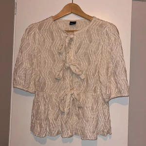 Blus från Gina tricot - Jätte gullig krämvit ”knyt” topp/blus från Gina tricot i storlek xs. Ny pris 499kr, mitt pris 169kr. Bara att skriva vid funderingar eller prisförslag!💕