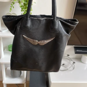 Väska - En jättenajs väska som passar utmärkt till skolstarten då den rymmer väldigt mycket, lite sliten på vissa ställen på det svarta skinnet men det får den att se lite vintage ut!
