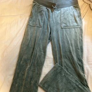 Gröna mjukisbyxor från Juicy Couture - Säljer ett par gröna mjukisbyxor från Juicy Couture i storlek M. Byxorna har en bekväm midja med snörning och praktiska fickor både fram och bak med knappar. Jag bytte dom med en annan tjej för ca 1 år 6 månader sen. Jag har använt dom fåtal gånger. Dom är i bra skick och väldigt bekväma.