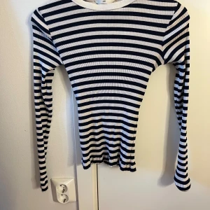 Randig ribbad tröja från H&M - Säljer en superfin randig tröja från H&M i storlek S, Den är marin blå och vit med ett ribbat mönster som ger en snygg textur. Tröjan har långa ärmar och är perfekt för både vardag och lite kyligare dagar. Passar till allt från jeans till kjol!