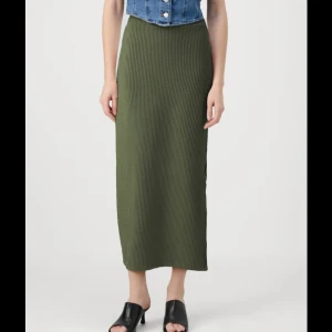 Olivgrön ribbad långkjol - Säljer en superfin olivgrön långkjol i ribbat material. Kjolen har en tight passform som sitter snyggt och bekvämt. Perfekt för både vardag och fest! 🥰