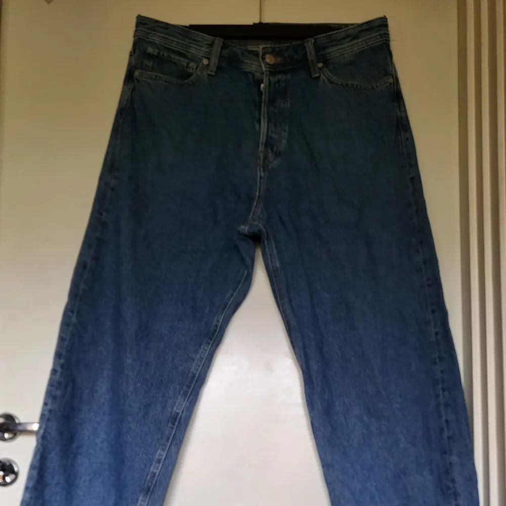 Säljer ett par blå baggy jeans från Jack & Jones i storlek 32/32. De är i bra skick och har en klassisk femficksdesign med dragkedja och knapp. Perfekta för en avslappnad och bekväm stil. Passar både till vardags och fest!. Jeans & Byxor.