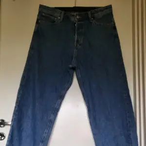 Säljer ett par blå baggy jeans från Jack & Jones i storlek 32/32. De är i bra skick och har en klassisk femficksdesign med dragkedja och knapp. Perfekta för en avslappnad och bekväm stil. Passar både till vardags och fest!