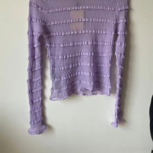 Lila tröja från MNG - Säljer en superfin lila tröja från MNG. Den är långärmad och har ett unikt ribbat mönster som ger en cool textur. Perfekt för både vardag och fest! 💜