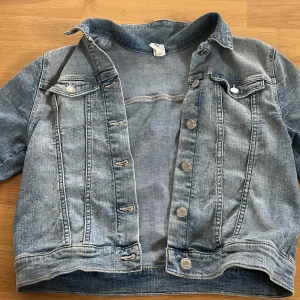 Jeansjacka från &Denim - Säljer en klassisk jeansjacka från HM  i en snygg ljusblå tvätt. Jackan har knappar framtill och två bröstfickor med knappstängning. 