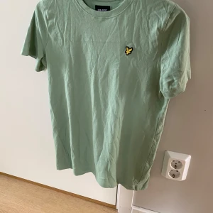 Lyle & Scott T-shirt Grön - Jättesnygg T-shirt från Lyle & Scott, aldrig använd. Storlek runt 160 cm, står 12/13 yrs på lappen men passar folk äldre än så, exempelvis mig. Enligt internet är tröjan för killar 12-13 år, men det är väl en tolkningsfråga. Öppen för prisförslag. 