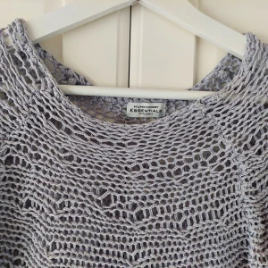 Blå stickad tröja från Hunkydory Essentials - Säljer en superfin blå stickad tröja från Hunkydory Essentials. Den har ett unikt nätmönster och är perfekt för lager-på-lager-stil. Tröjan är långärmad och har en lite längre bakdel för en cool look. Perfekt för både vår och höst!