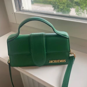 Jacquemus bambino  - Grön bambino väska från Jacquemus. Varsamt använd. Mått 17,5 x 9 cm Köpt ny från Miinto för 2 år sedan ungefär. Justerbart axelband Priset kan diskuteras vid snabb affär. Säljs med dustbag 