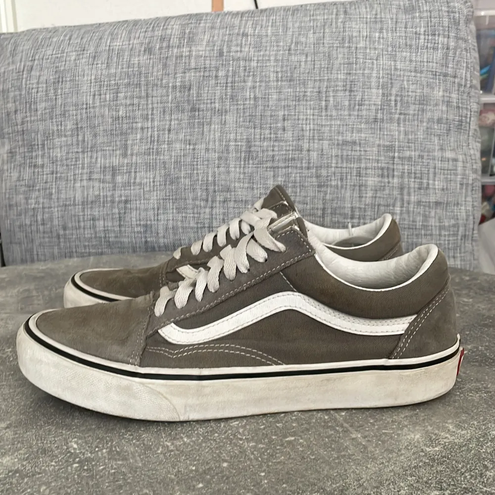 Säljer ett par grå Vans old skool i okej skick. De har en klassisk design med vit sula och vita snören. Perfekta för vardagsbruk och ger en skön, avslappnad stil.. Skor.