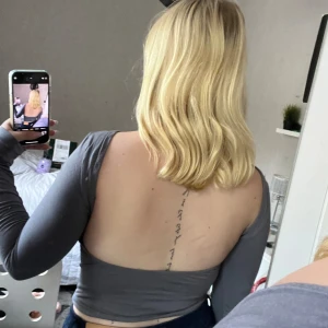 En grå långärmad skjorta med öppen rygg. - Använd få gånger och i bra skivk