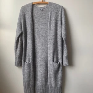 Stickad kofta - Stickad lång grå kofta. Står storlek 146/152 men passar XS
