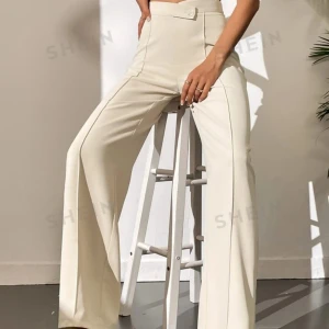 Beige vida byxor från Shein - Säljer ett par snygga beige byxor från Shein. De är högmidjade och har en vid passform som ger en elegant look. Perfekta för både vardag och fest! Byxorna har en stilren design med knappar i midjan.